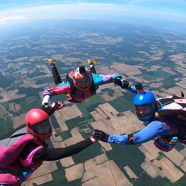 A 3-person group of licensed skydivers in belly formation over Iowa.