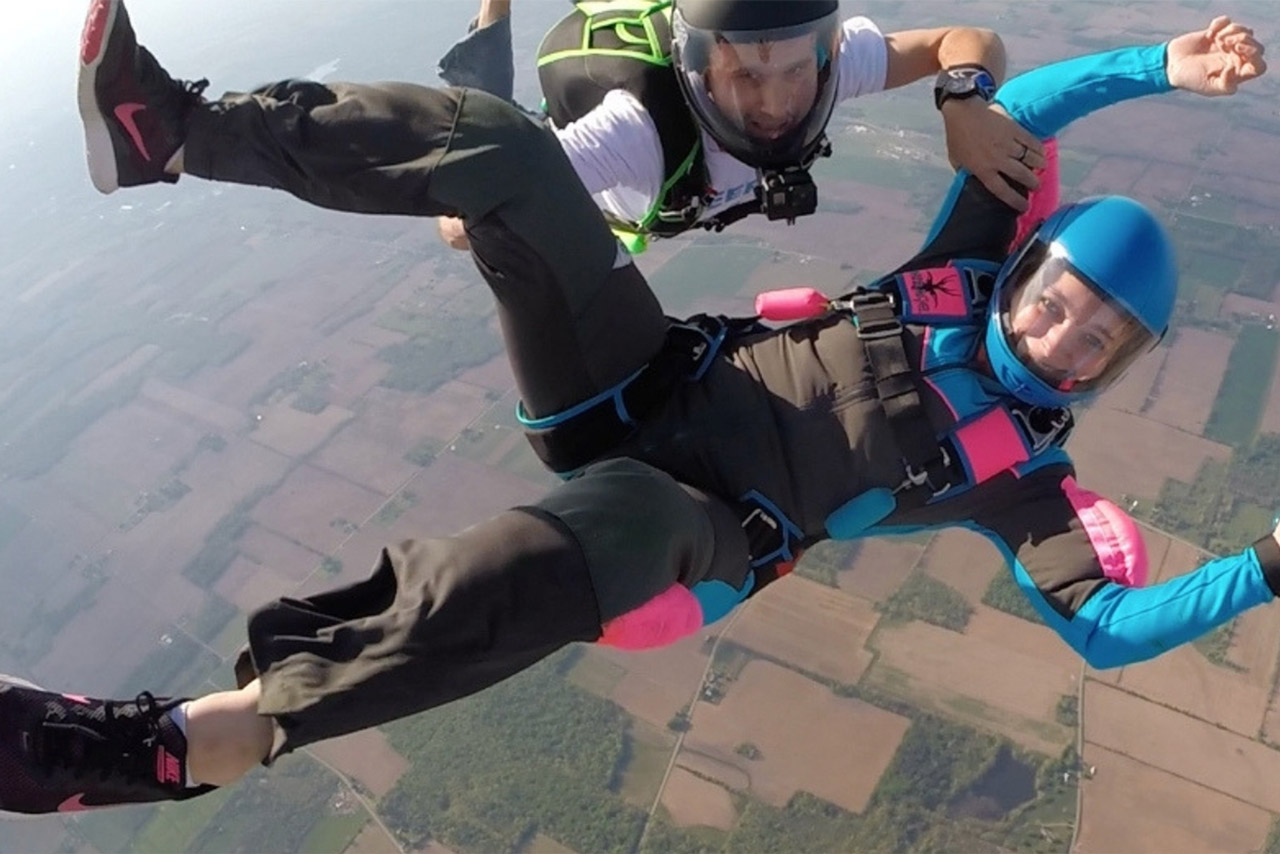 Female skydiving student flying on her back with her instructor along side her.