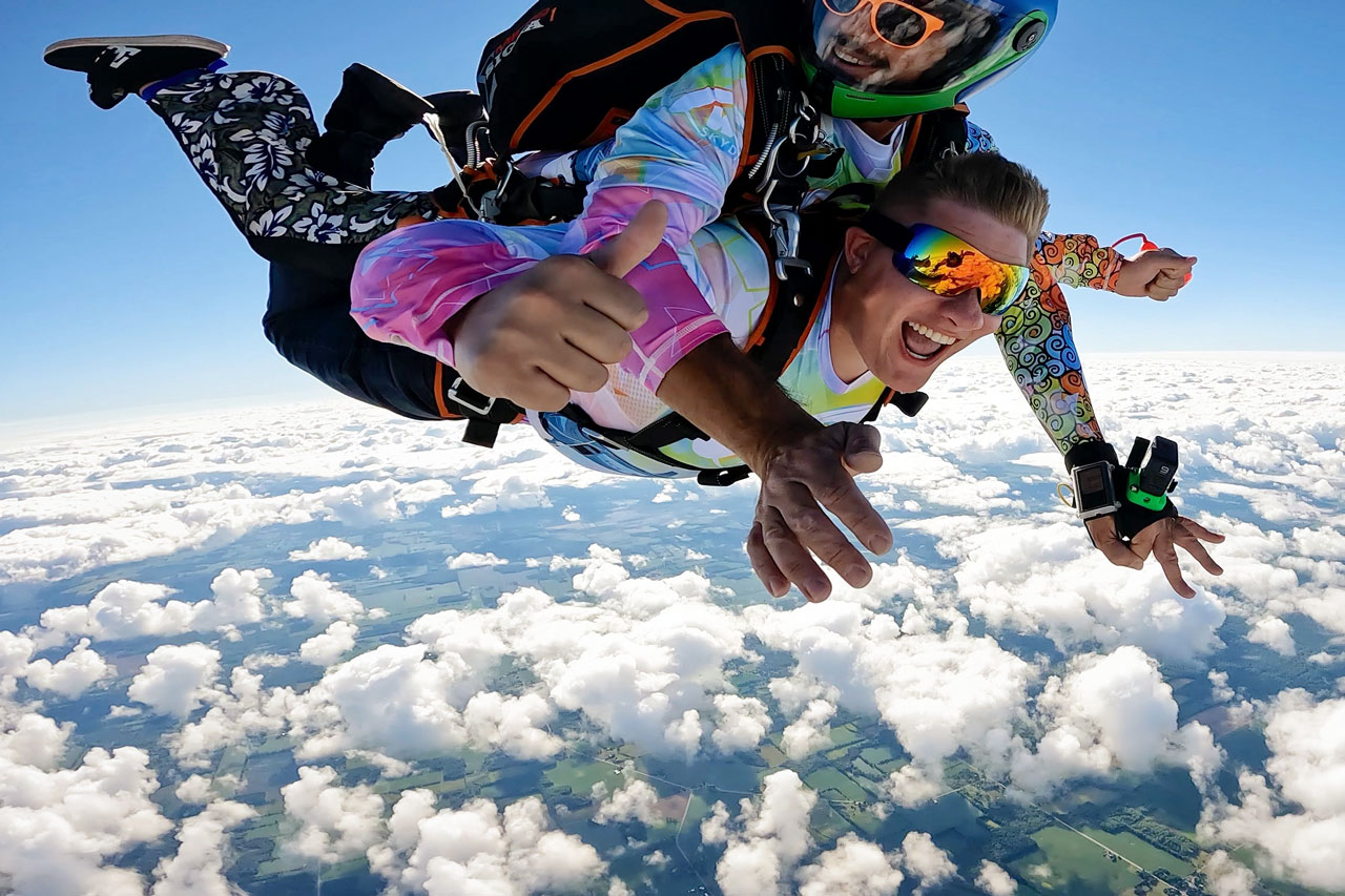 Outside view of tandem skydiving male pair captured by skydiving photographer.